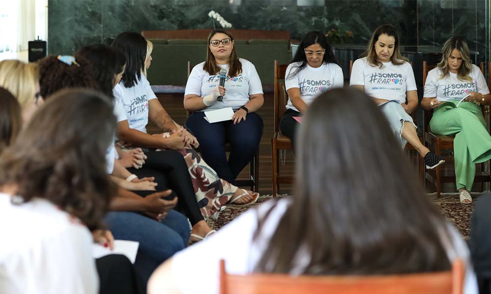 Juliene Matos, vice-presidente da DEBRA Brasil, tem o microfone na mão e dá o seu depoimento numa roda de conversa com mães de crianças raras/pessoas com doenças raras