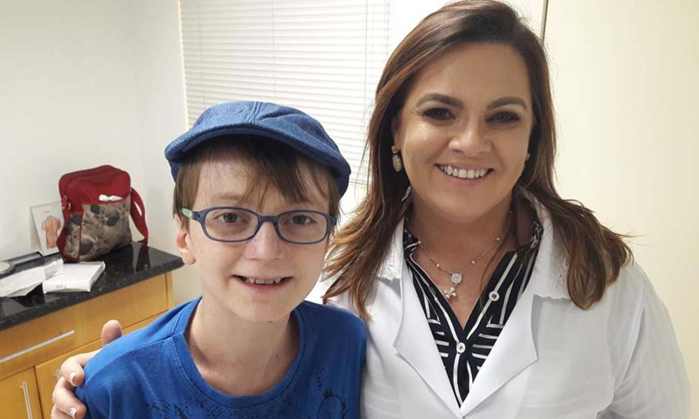 Dra. Jeanine, diretora médica da DEBRA Brasil, abraçada com o seu paciente e afilhado Emanuel, que nasceu com epidermólise bolhosa distrófica recessiva (EB)