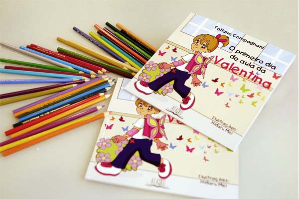 Dois livros da Tatiane Compagnoni, “O primeiro dia de aula da Valentina”, com vários lápis coloridos. A Tatiane é mãe da Valentina, que nasceu com epidermólise bolhosa (EB)