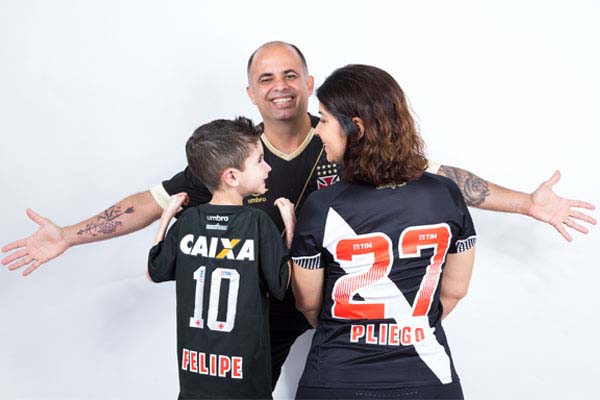 Felipe, um menino com epidermólise bolhosa (EB), com a mãe e o pai, todos vestindo a camiseta do Vasco da Gama