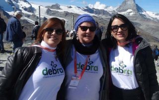 Dra. Jeanine, presidente da DEBRA Brasil, Louisa Huber, vice-presidente da AFAPEB e Dra. Rosalie, médica voluntária da DEBRA, tiram foto nas montanhas da Suiça, onde aconteceu o Congresso da DEBRA International.