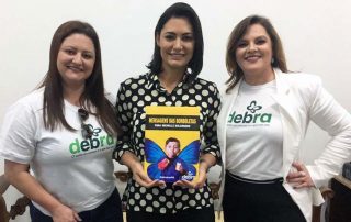 Dra. Jeanine Magno, presidente da DEBRA Brasil, entrega o livro “Mensagem das borboletas para Michelle Bolsonaro” para a primeira-dama.